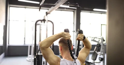 Athlete pulls rope cable during back strength training workout Stock Footage 312157032