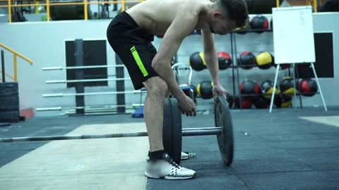 An Athlete Puts Additional Weights on a Barbell. Stock Footage 132724399