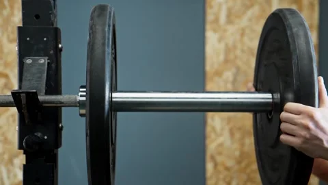 Athlete puts additional weights on barbell. Prepare to do exercises with barbell Stock Footage 272270453