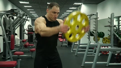 An athlete raises a disc, an exercise for hands Stock Footage 93501249