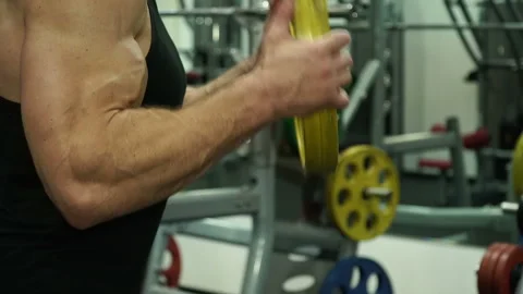 An athlete raises a disc, an exercise for hands Stock Footage 93502394