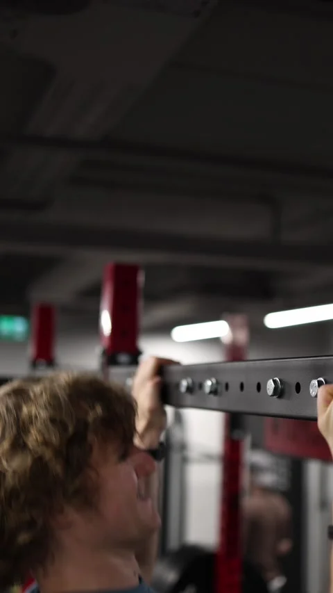Athlete reaches the top of a controlled pullup repetition Stock Footage 339321484