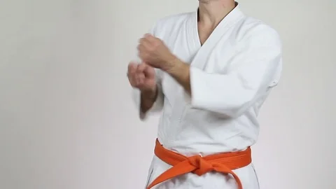 Athlete with a red belt on a light background makes the punch 動画素材 70498588