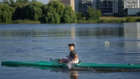 Athlete is rowing kayak against background of quiet lake. Stock Footage 274454640