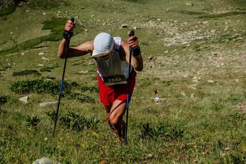 Athlete runner steep climb during mountain marathon Stock Photos