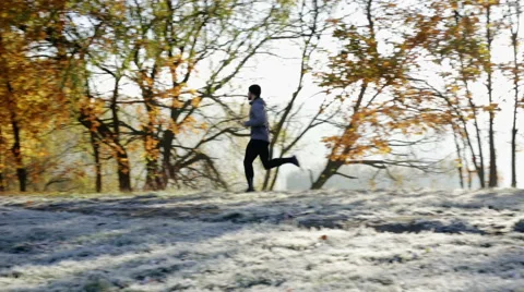 Athlete running at park during cold autumn morning Stock Footage 57819141