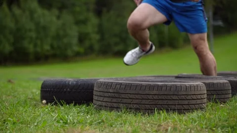 Athlete running through tires during outdoor workout Stock Footage 316911665