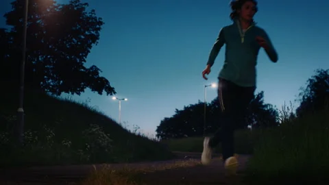 Athlete Runs Past Camera in Early Morning Dusk Light Stock Footage 158317360