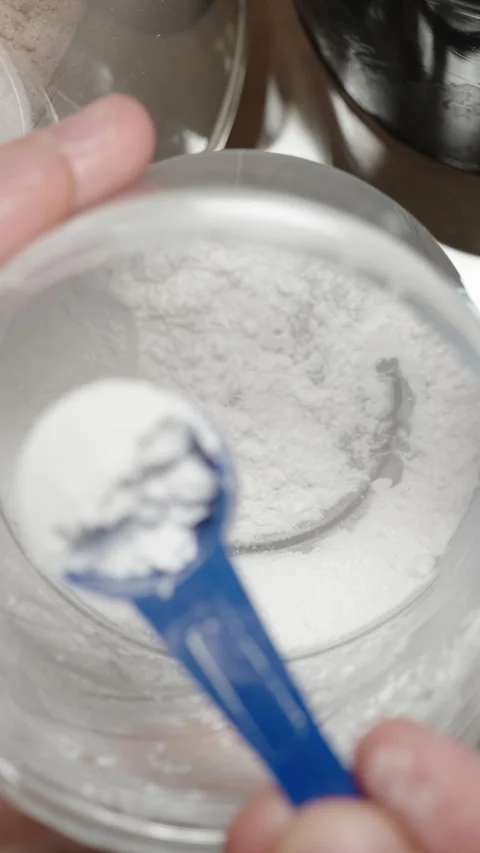Athlete scooping pre-workout powder from a jar, preparing to add it to their Stock Footage 283783230