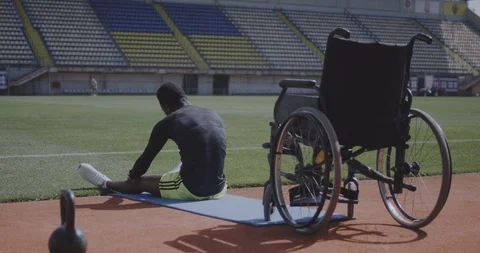 Athlete sitting on ground and warming up Stock Footage 116764359