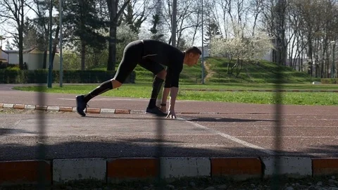 Athlete at starting line from block start position running on race track in t Stock Footage 77738125