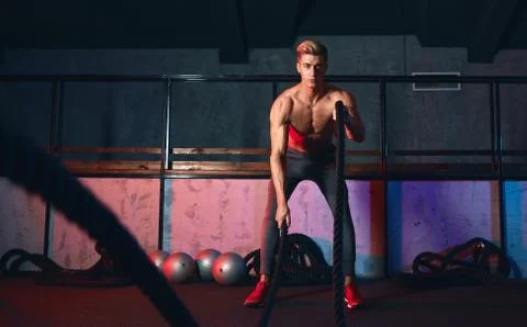 Athlete stops doing boring cardio workouts and starts using battle ropes. Stock Photos