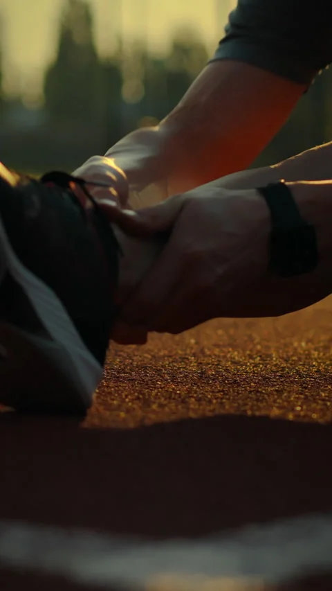 Athlete stretches on outdoor track while experiencing discomfort during trai Stock Footage 331535068