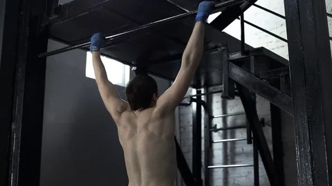 An athlete in training does pull-ups in a boxing gym Stock Footage 76500967