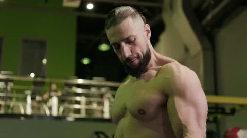 An athlete trains and does biceps exercises with dumbbells in the gym. Close up Stock Footage 234326544