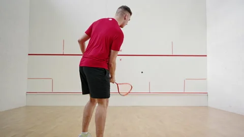 Athlete trains hitting balls with racket on squash court Stock Footage 220957585