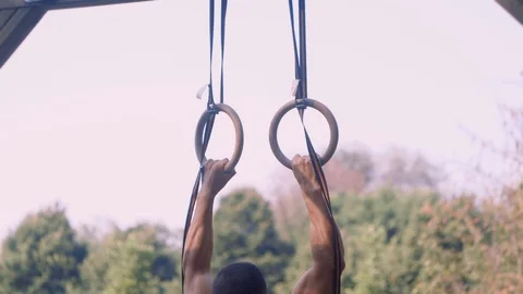 Athlete trains on the rings, he pulls up Video stock 99891226