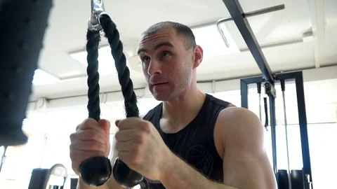 The athlete trains in the simulator, triceps exercise Vídeo Stock 85952956