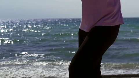 Athlete trains at sunset in the evening on the beach. a man fulfills kickboxing Видео 107656621
