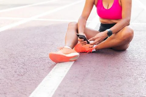 Athlete using her mobile phone after her workout Stock Photos