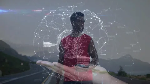 Athlete using smartphone on highway, initiating code forming hologram globe 動画素材 313242852