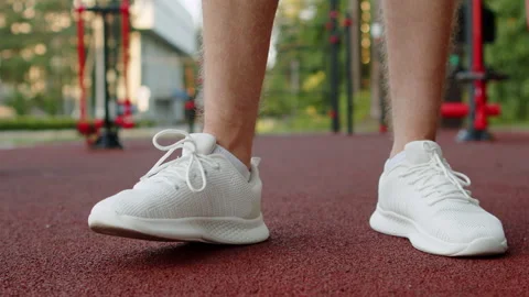 Athlete waiting on an outside training ground. Foot tapping in white sneake.. Video stock 341457753