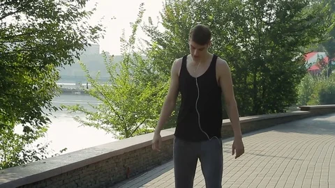 An athlete warms up during an early morning workout in a city park Stock Footage