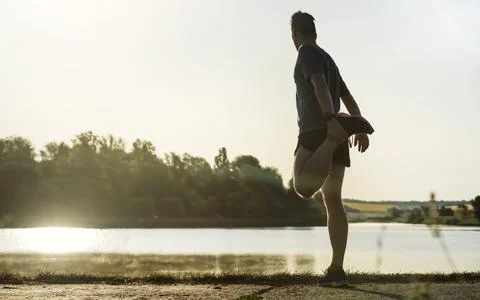 The athlete warms up before running. Stock Photos
