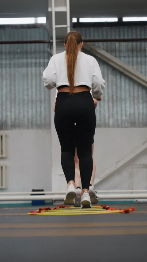 Athlete working on footwork with agility ladder indoors. Indoor athletic Stock Footage 341767120