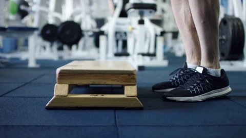 Athlete working out on a step board in a gym, side profile shot Stock Footage 105877013
