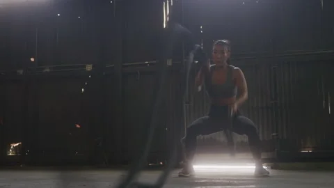 Athlete in Workout Clothes Exercises with Heavy Ropes in Warehouse Gym Stock Footage 208797281