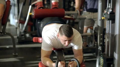The athlete works on his hamstrings using exerciser in the modern gym. Stock Footage 85425159