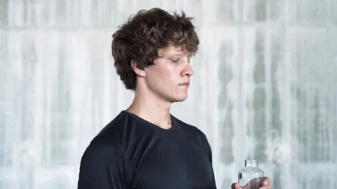 Athlete young thirsty man drinking water from bottle after intense exercise. Stock Footage 112655572