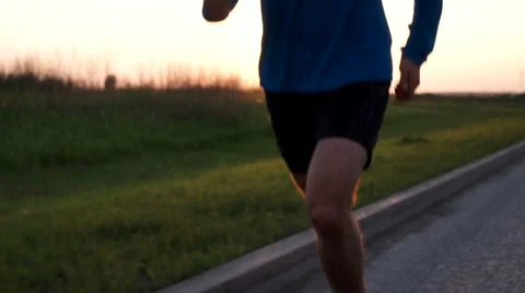 The athlete's body of a runner close-up while Jogging Видео 64496096