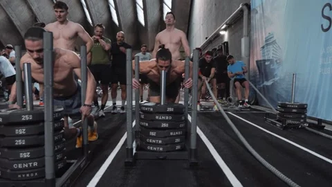 Athletes competing in the intense Sled Push event at a Hyrox fitness challenge Stock Footage 337799525