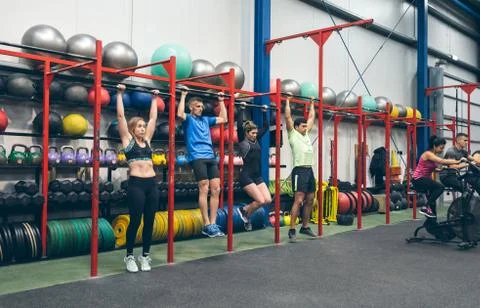 Athletes doing pull ups in the gym Stock Photos