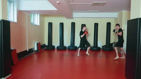 Athletes engaged in sparring practice inside martial arts gym, delivering Stock Footage 321099562