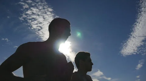 Athletes exercising and running against blue sky. Healthy active sport lifestyle Stock Footage