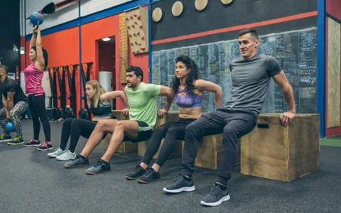 Athletes exercising doing box squats Stock Photos