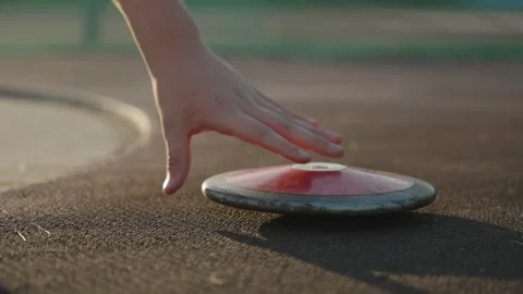 An athlete's hand picks up a close-up of a throwing disc from the floor Stock Footage 320393255