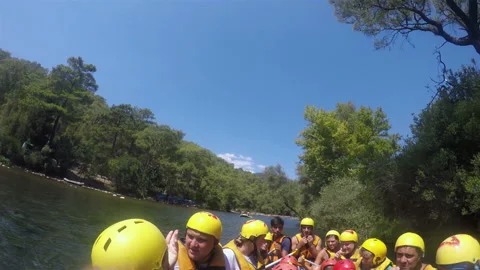 Athletes in helmets and vests with oars in their hands sit in a boat floating on Stock Footage 128314138