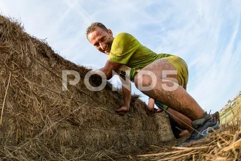 Athletes overcoming the hay osbtacle Stock Photos