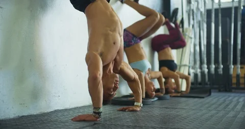 Athletes performing headstand push ups together Stock Footage 104017851