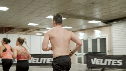 Athletes running during a high-intensity Hyrox fitness race, showcasing Stock Footage 337799472