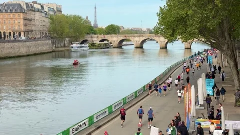Athletes running the Paris Marathon along the Seine river Stock Footage 337024203