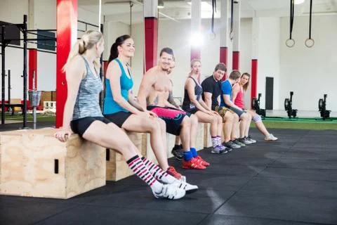 Athletes Sitting On Boxes During Workout Break In Gym Stock Photos