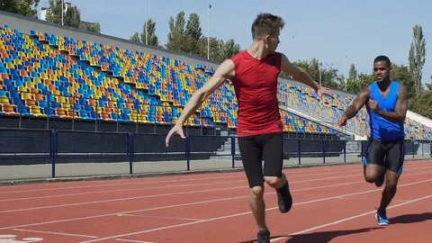 Athletes training relay race on empty stadium, teamwork, aspiration to win Stock Footage 84434573