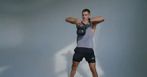 Athletic 23-Year-Old Man Engages in Strength Training in Studio Stock Footage 344278160