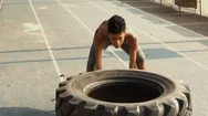 Athletic African Woman Flipping Tire In A Fitness Class Stock Footage