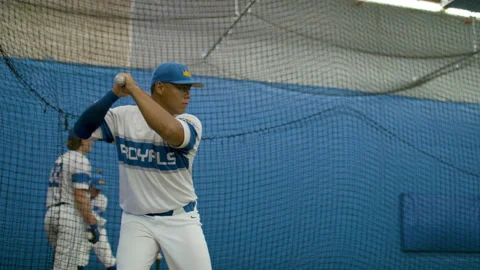 Athletic baseball player practising his swing in a training facility. Stock Footage 134494604